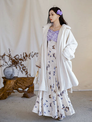 Elegant eco-friendly winter outfit featuring a white fur jacket paired with a velvet fishtail skirt adorned with butterfly prints.