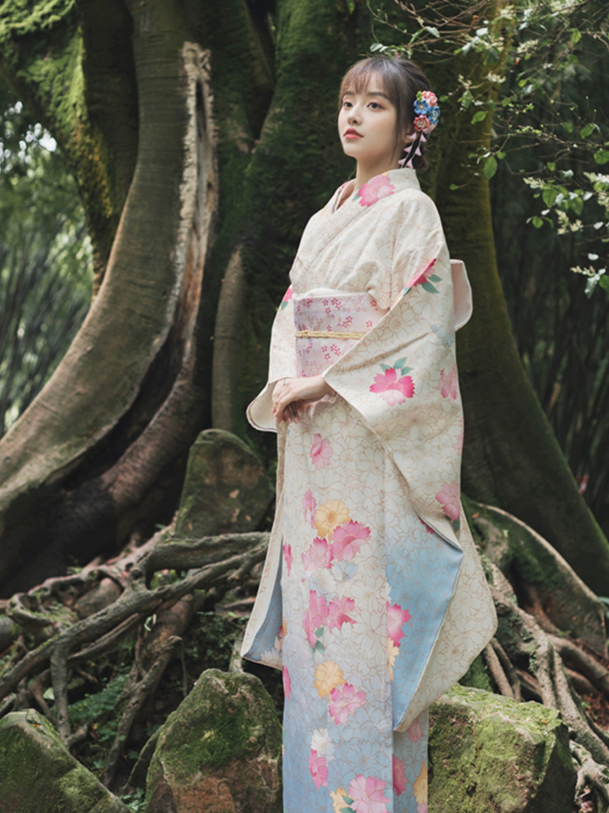 Elegant white Japanese kimono with floral patterns, worn in a serene forest setting.