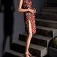 Red cheongsam with crane print and split skirt, styled with black heels.