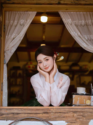 Elegant green hanbok with floral embroidery, viewed through a wooden window.