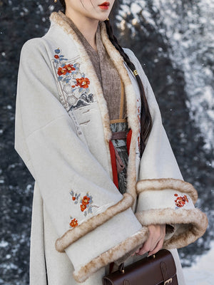 Close-up of white woolen Hanfu coat with vibrant floral embroidery and plush faux fur accents for a warm, elegant style.