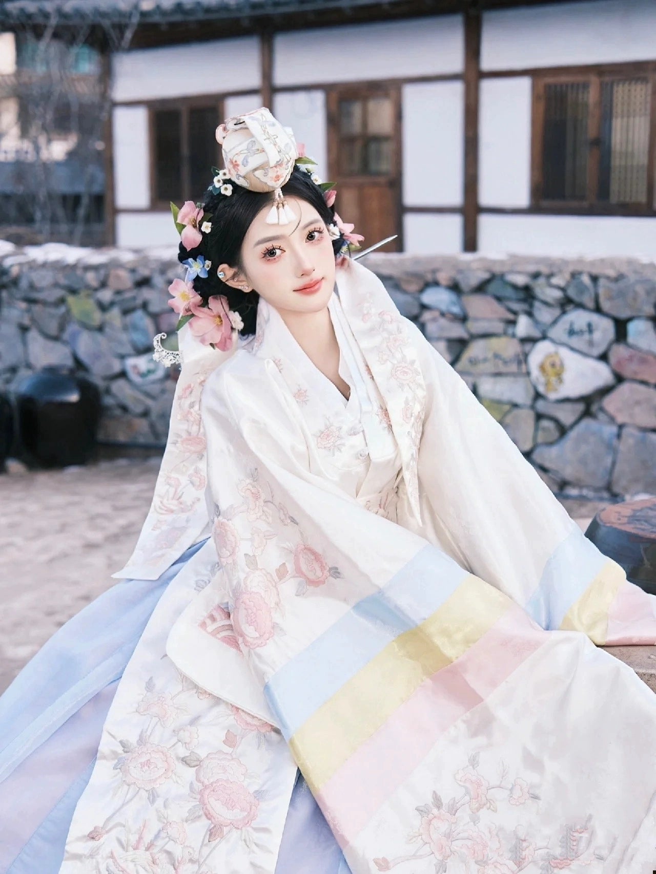 Bride in a Muzhi white Korean embroidered wedding dress, showcasing intricate floral patterns and pastel hues for a sophisticated wedding style.