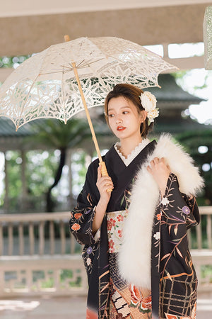 Black kimono with butterfly and floral designs, paired with a white fur shawl.