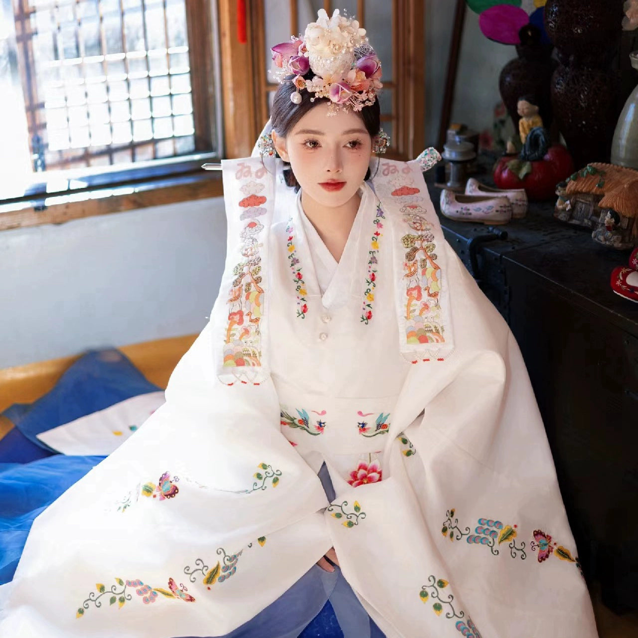 White Korean hanbok with floral embroidery, perfect for traditional weddings.