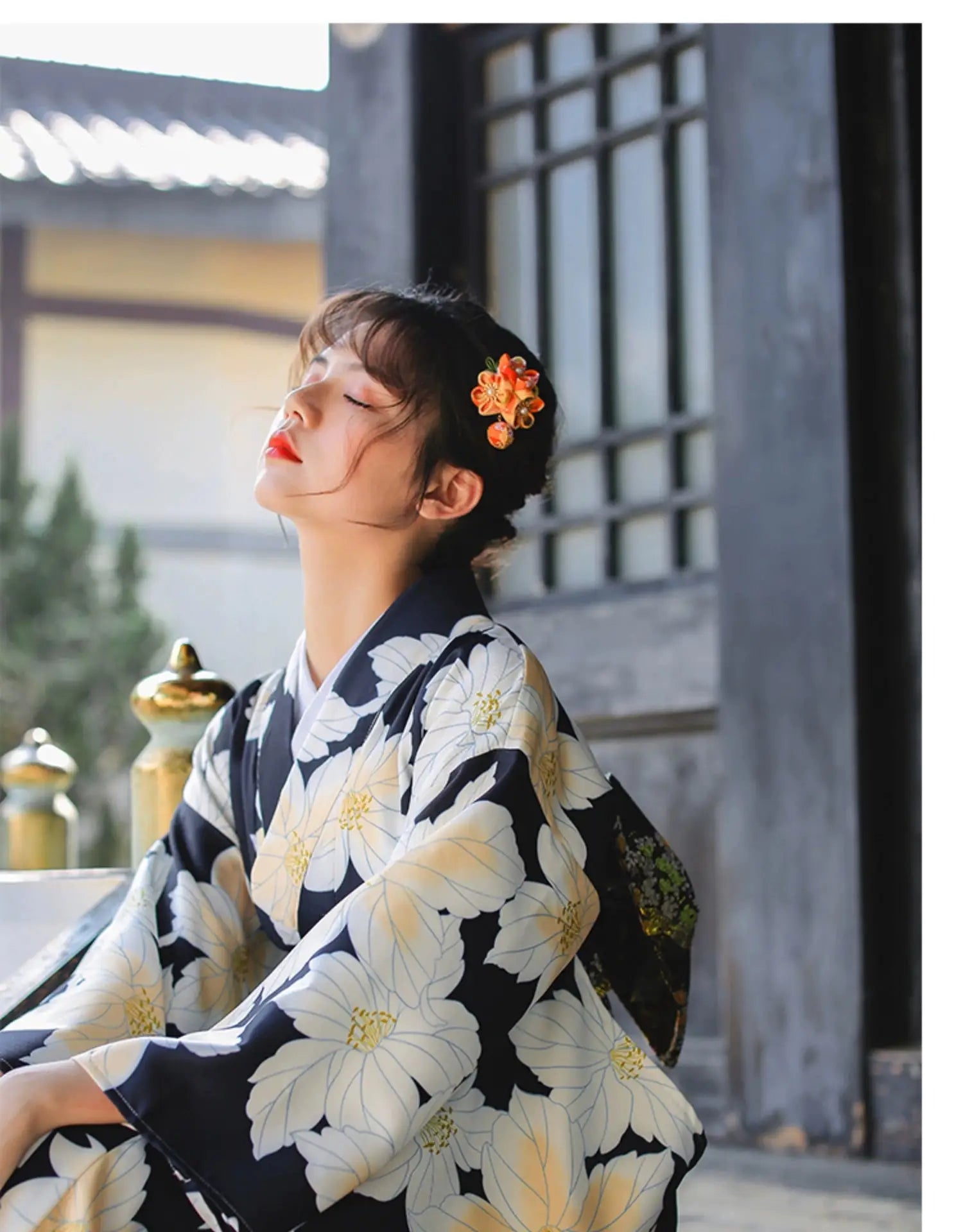 Woman in a Japanese kimono dress with a floral design, posing outdoors, highlighting its elegance and traditional style.