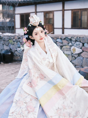 Elegant white Korean embroidered wedding dress by Muzhi, featuring intricate floral patterns and pastel accents for a traditional bridal look.