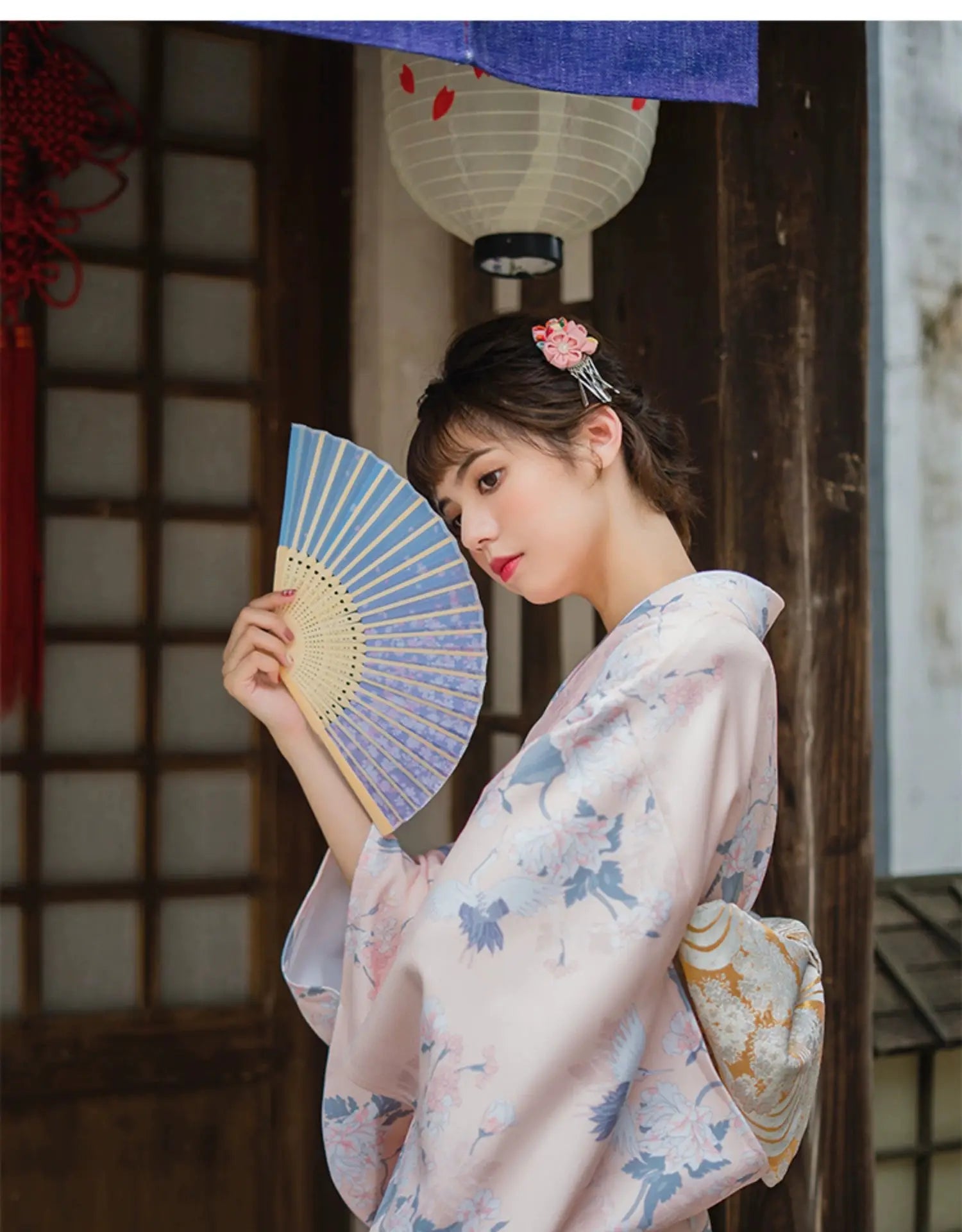 Detailed fabric view of a pink yukata kimono with crane and floral patterns, showcasing its intricate and traditional Japanese design.