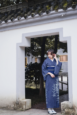 Full-length view of blue Japanese kimono yukata in a traditional setting.