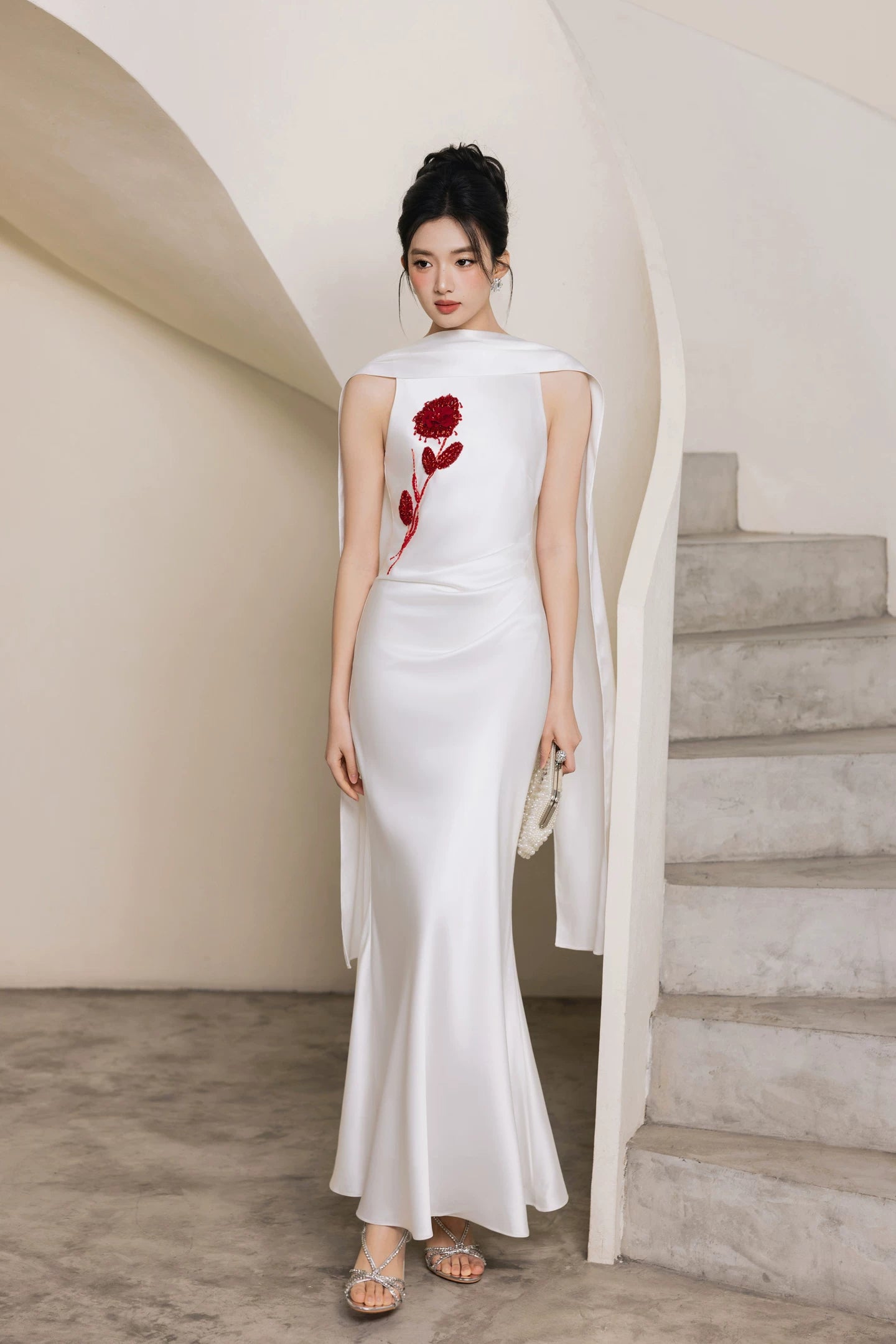 White floral beaded formal gown, full front view by curved staircase