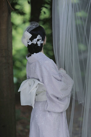 Rear view of a purple lace kimono showcasing its intricate bow detail.