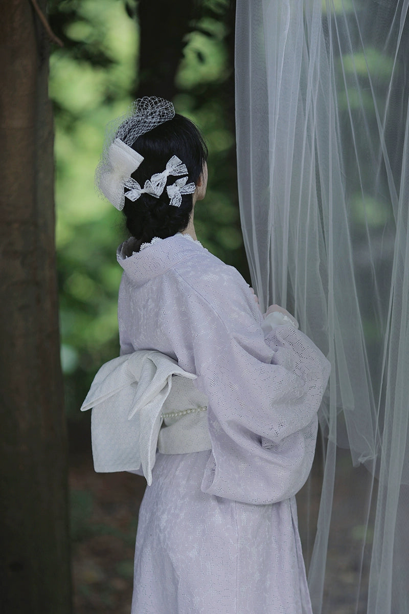 Rear view of a purple lace kimono showcasing its intricate bow detail.