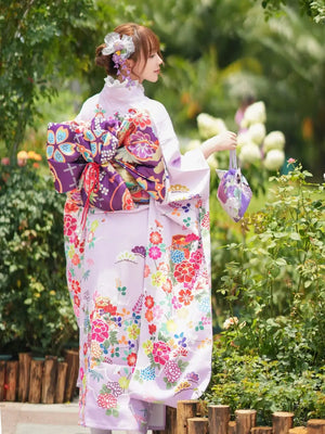 Back view of a Japanese kimono featuring intricate floral designs, a decorative obi, and a matching accessory, ideal for cultural events.