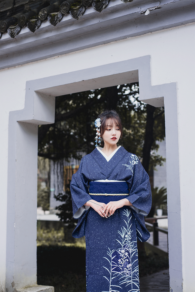 Blue Japanese kimono yukata worn in a traditional outdoor setting.