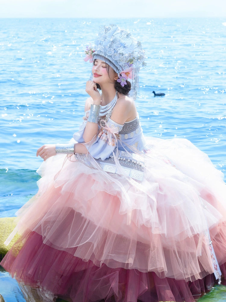 Elegant Pink Miao Clothing Women's Summer Cake Green Dress featuring ombre tulle layers and traditional silver accessories by the seaside.