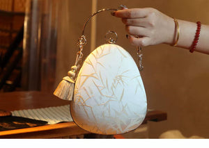 Bamboo handbag held by its curved handle