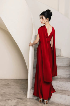 Back view of red hand-beaded evening gown with draped cape panels