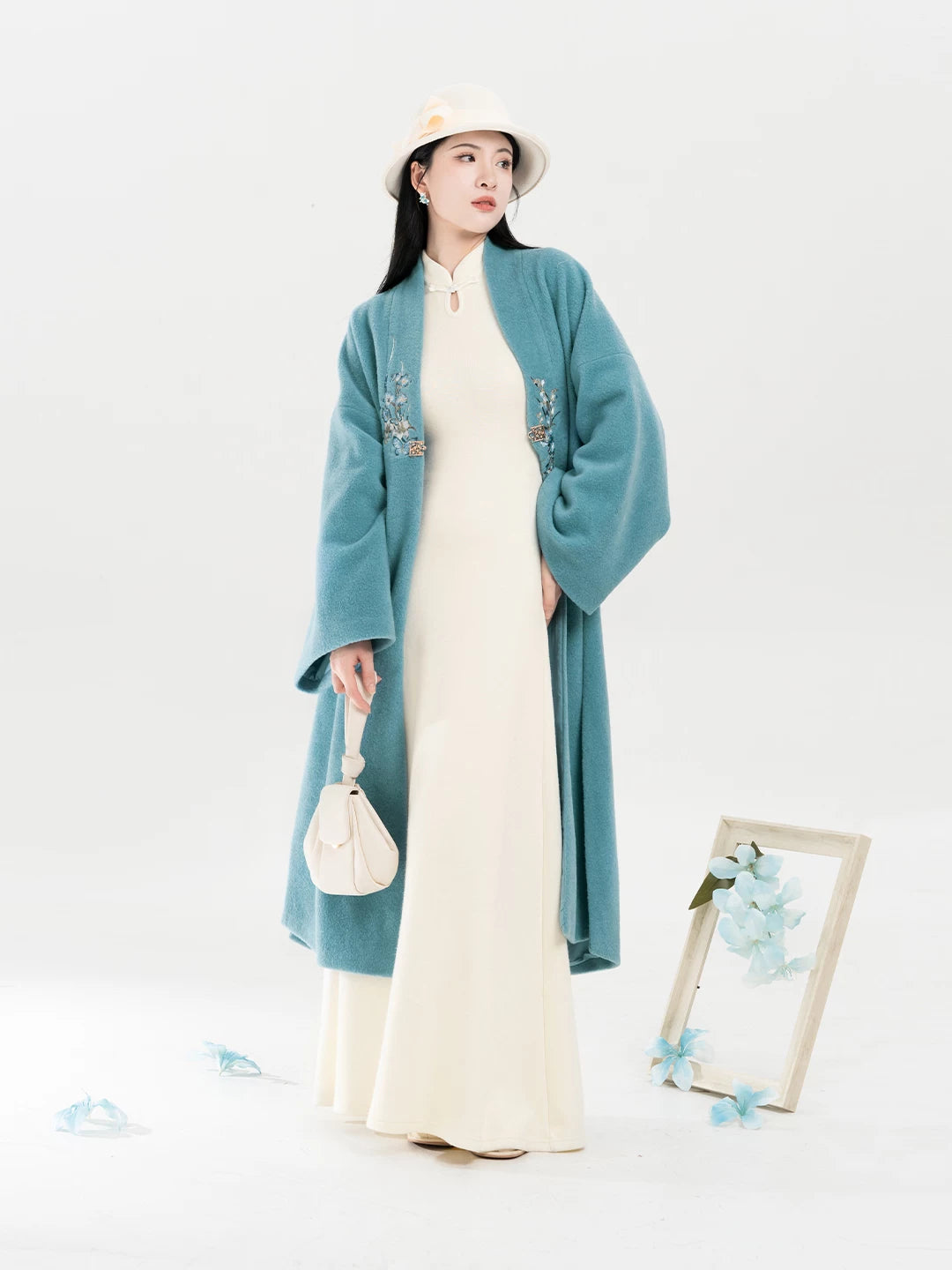 Teal floral coat and ivory dress standing pose