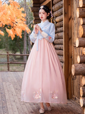 Charming blue and pink hanbok with embroidered floral patterns, perfect for traditional Korean celebrations.