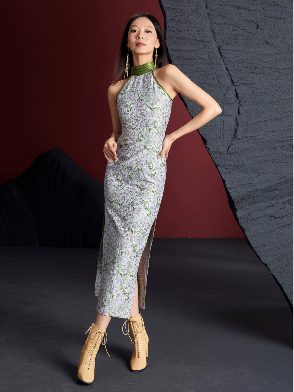 Retro jacquard sleeveless long cheongsam with green floral pattern and high slit, styled with beige lace-up boots. Custom cotton-silk blend fabric.