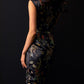 Back view of black cheongsam with dragon and phoenix jacquard design and tailored fit.