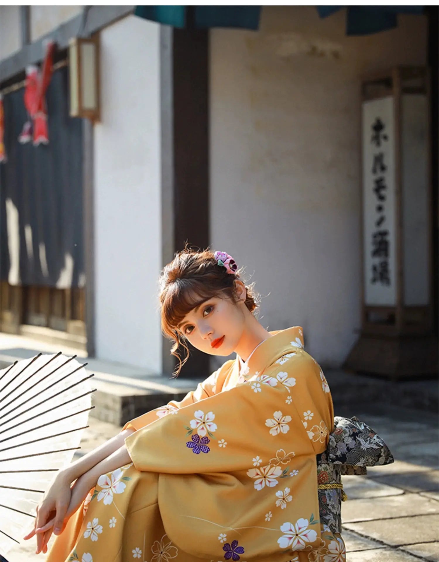 Close-up of a woman in an orange floral kimono yukata holding a traditional umbrella, with intricate flower patterns and soft lighting.