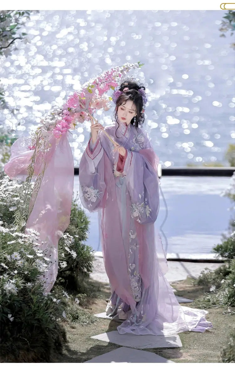 Woman in purple Hanfu with floral umbrella by water