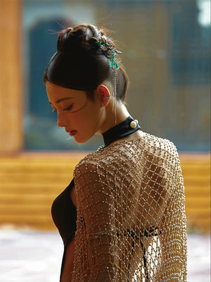 Close-up of a black fishtail cheongsam dress with a sheer gold beaded shawl, showcasing intricate details and craftsmanship.