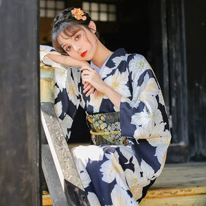 Close-up of a woman in a Japanese kimono dress, highlighting the floral pattern and detailed obi belt for a sophisticated look.