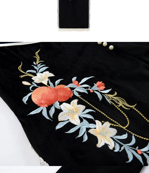 Detailed embroidery of pomegranate and floral designs on black cheongsam dress, showcasing elegant craftsmanship.