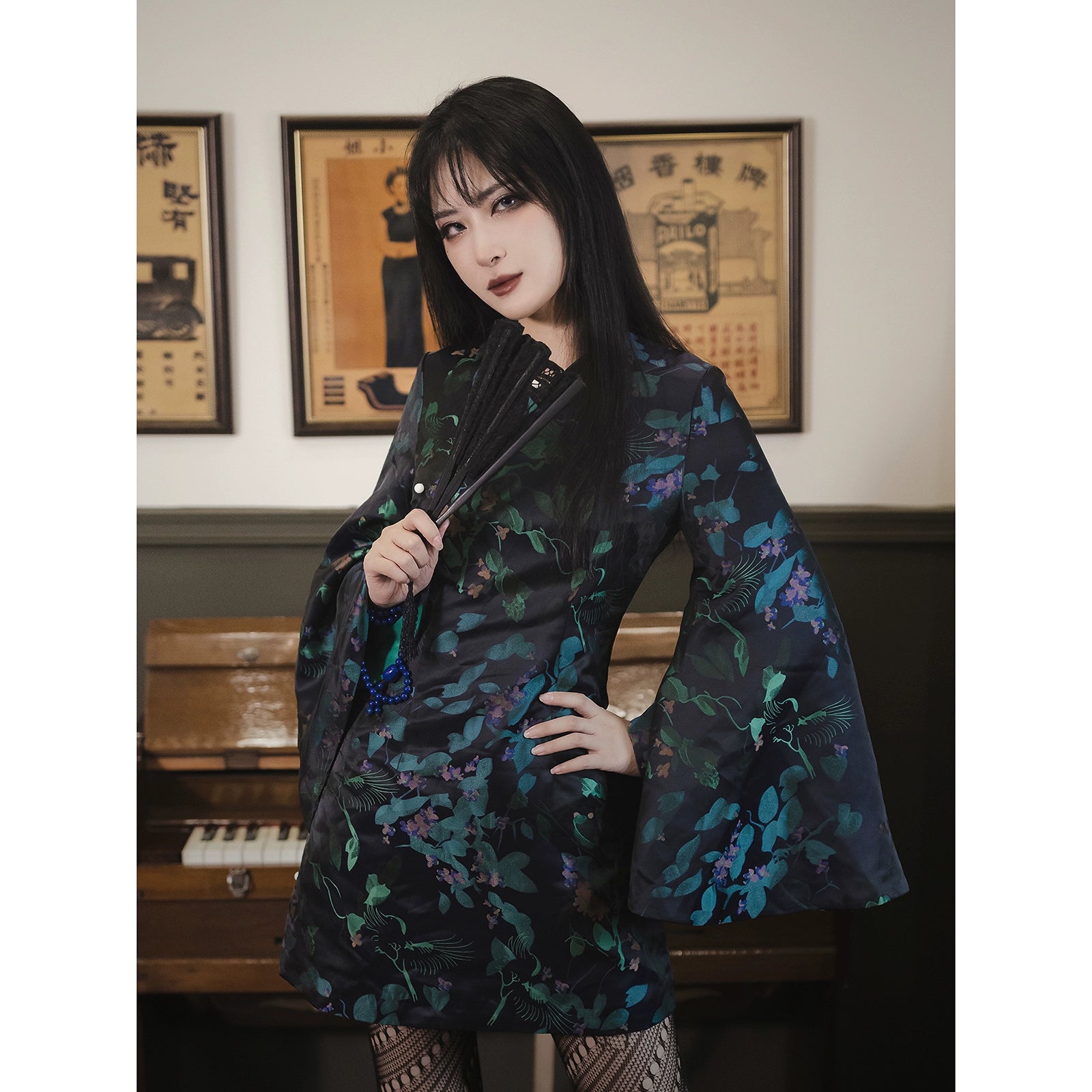 Vintage-inspired black cheongsam dress with green floral patterns, half sleeves, and non-elastic fabric. Styled with intricate jacquard details.