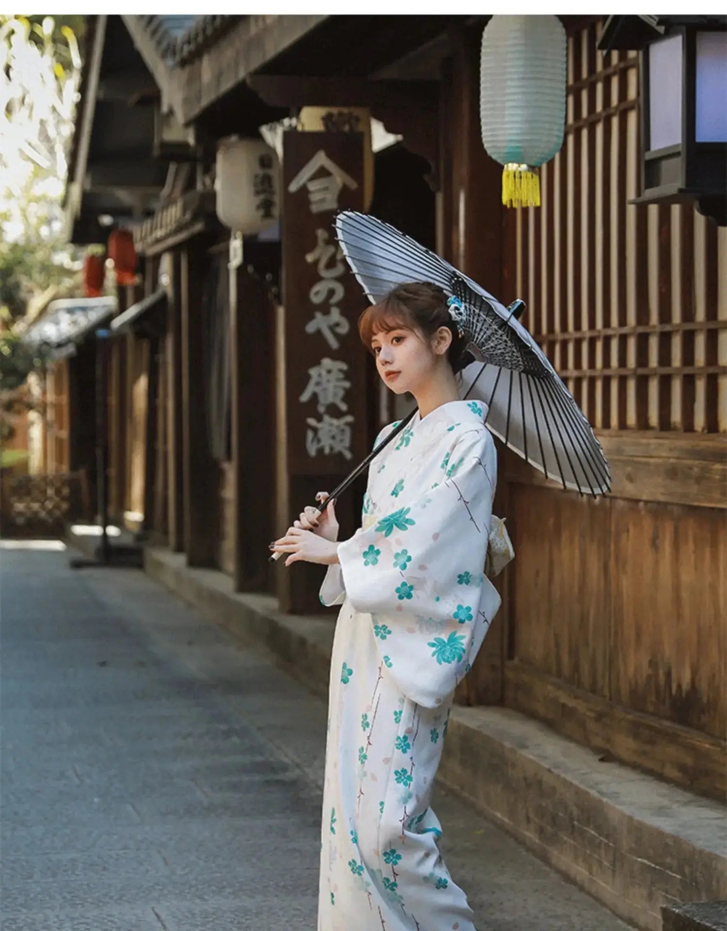 Stylish white and blue floral Yukata Kimono Dress paired with a parasol, worn by a woman in a traditional Japanese street.