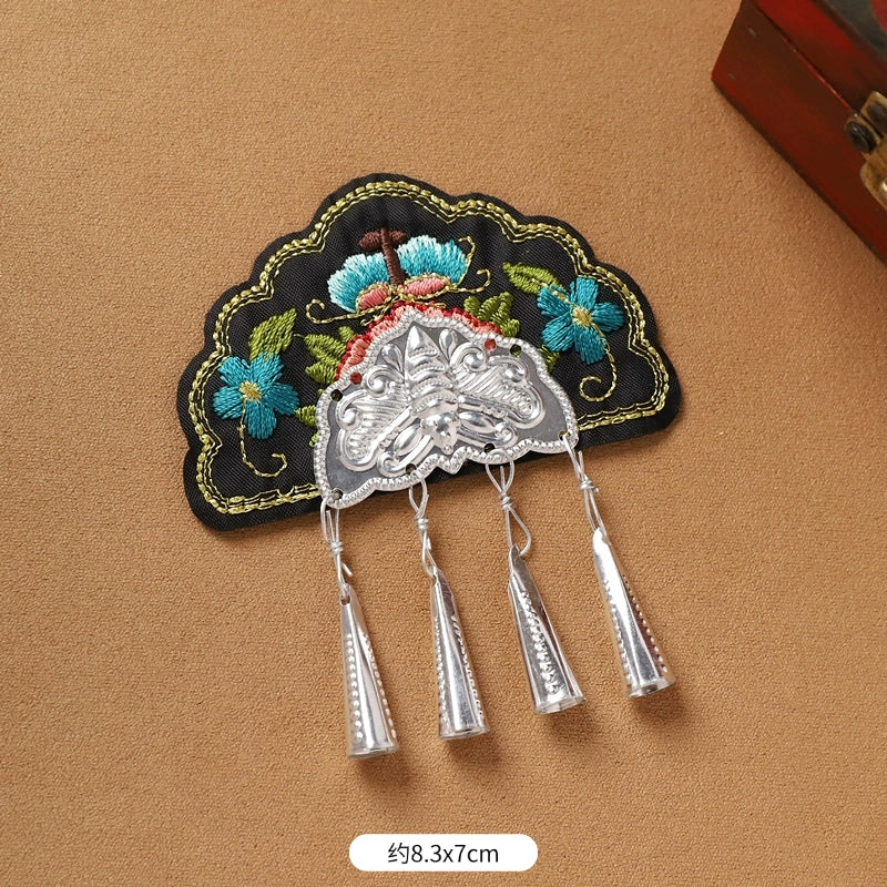Black embroidered Guizhou Miao fridge magnet with silver cone fringe, 8.3x7cm, handmade cultural kitchen accessory.