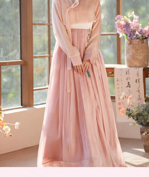 Elegant hanbok dress in soft pink, adorned with a tassel accessory. A perfect outfit for cultural celebrations and formal events.