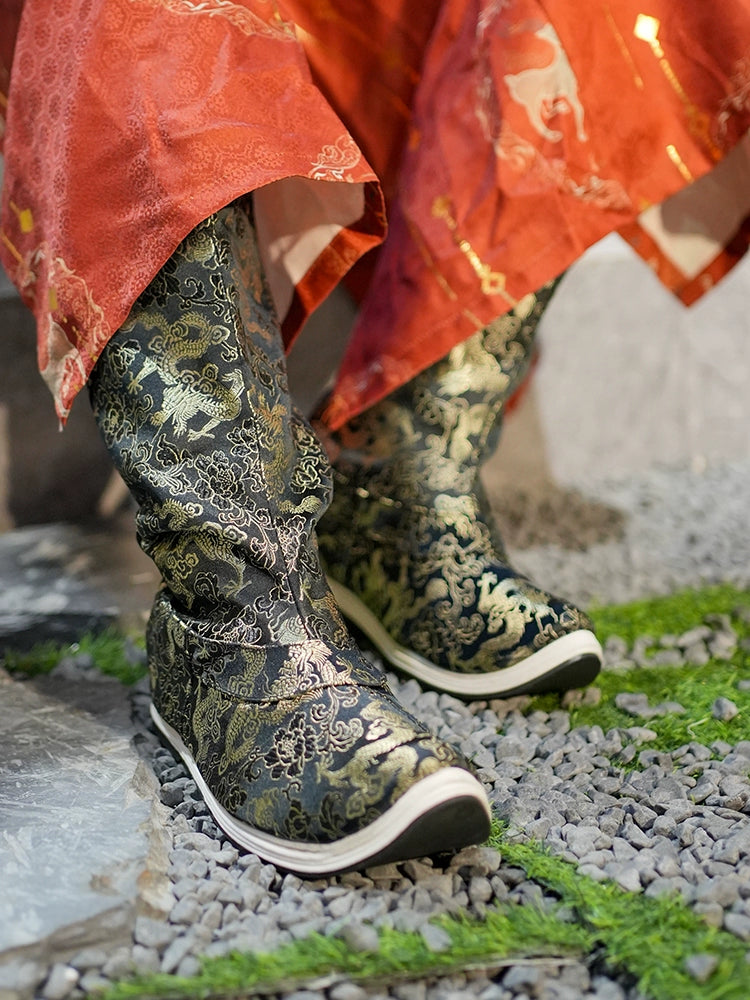 Black and gold embroidered Dragon boots with a curved sole, paired with a red Hanfu robe, inspired by Ming-dynasty aesthetics.