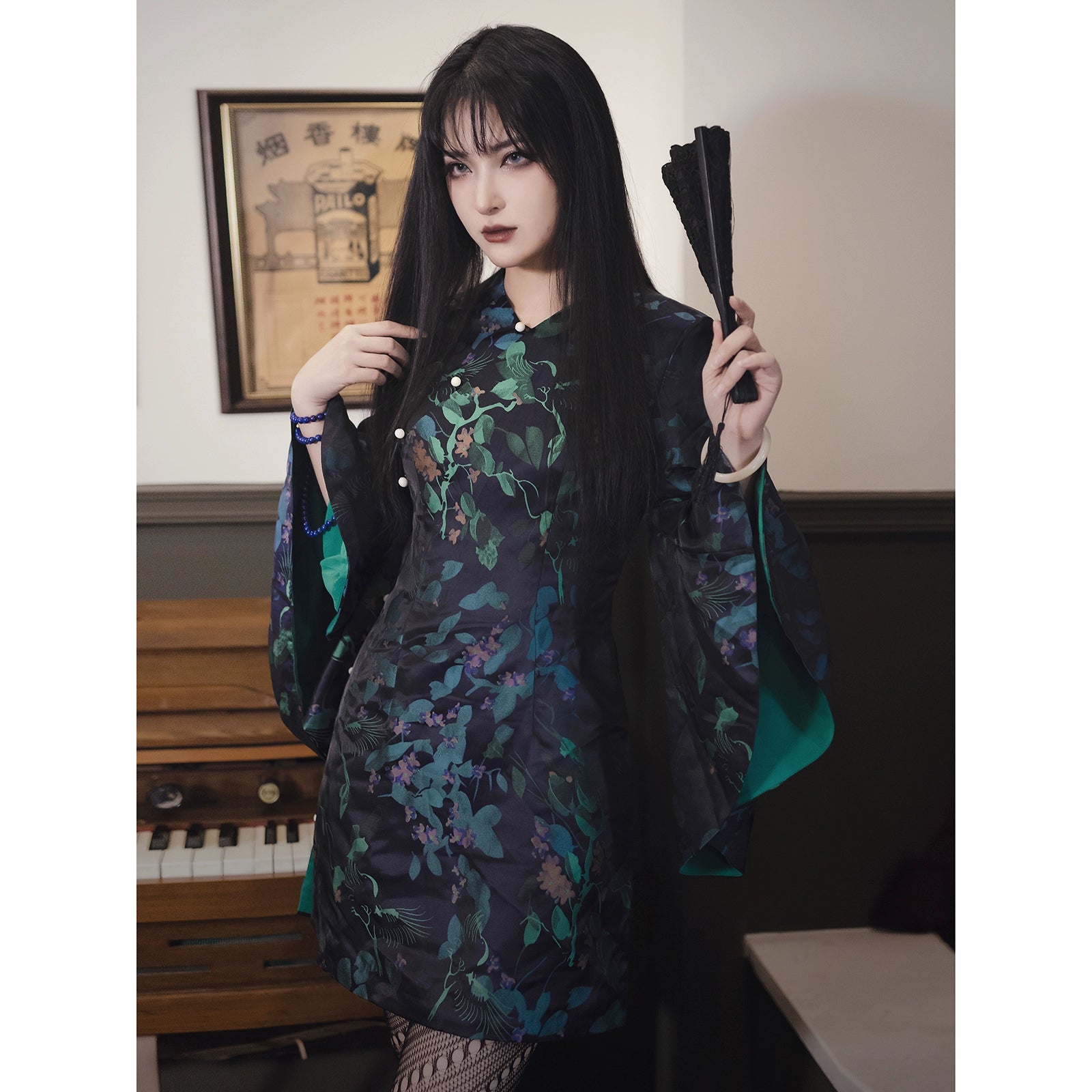 Black and green retro cheongsam short skirt with floral jacquard brocade, featuring bell sleeves and a fitted silhouette. Made of polyester, viscose, and cotton.