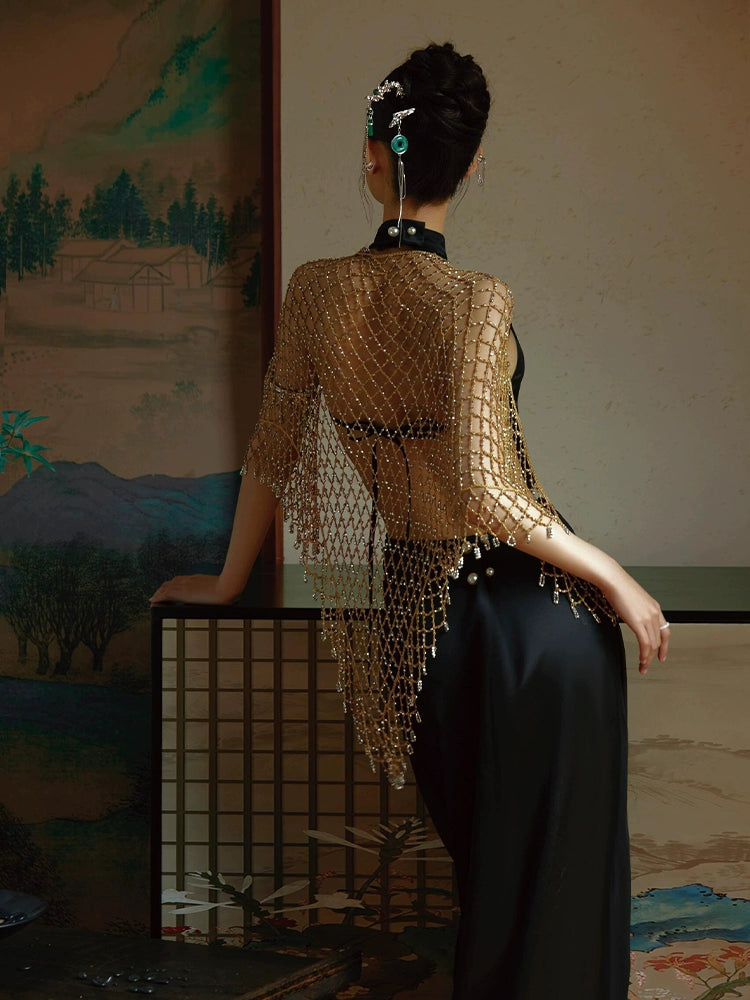 Back view of a black fishtail cheongsam dress with a sheer gold beaded shawl, styled in a traditional setting.