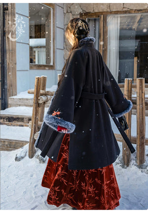 Back view of black woolen Hanfu coat with a belted design, floral embroidery, and faux fur cuffs, paired with a red pleated skirt.