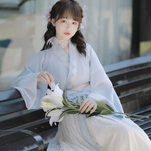 Modern Hanfu dress in soft blue with lace trim and floral embroidery, styled for spring with a romantic and traditional Chinese aesthetic.