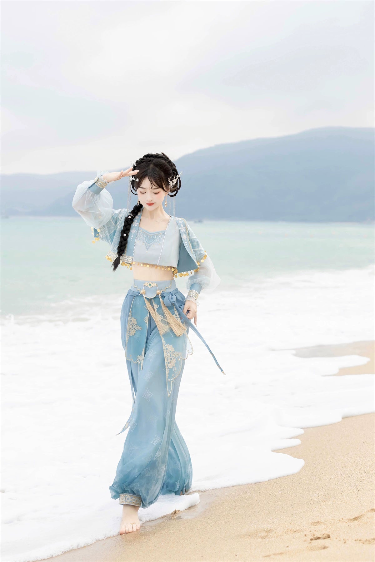 Walking along the beach in blue Hanfu Princess Jasmine suit by 【Cloud Traveler】, showcasing ethnic elegance and flowing fabric.