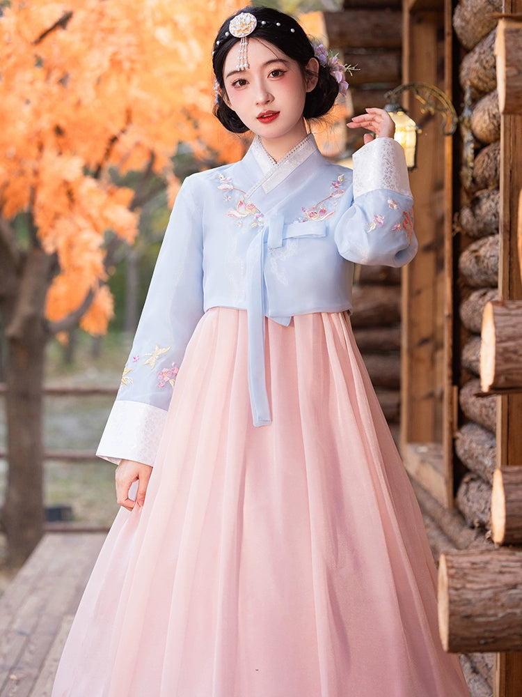 Elegant blue and pink traditional Korean hanbok with floral embroidery, perfect for cultural events and celebrations.