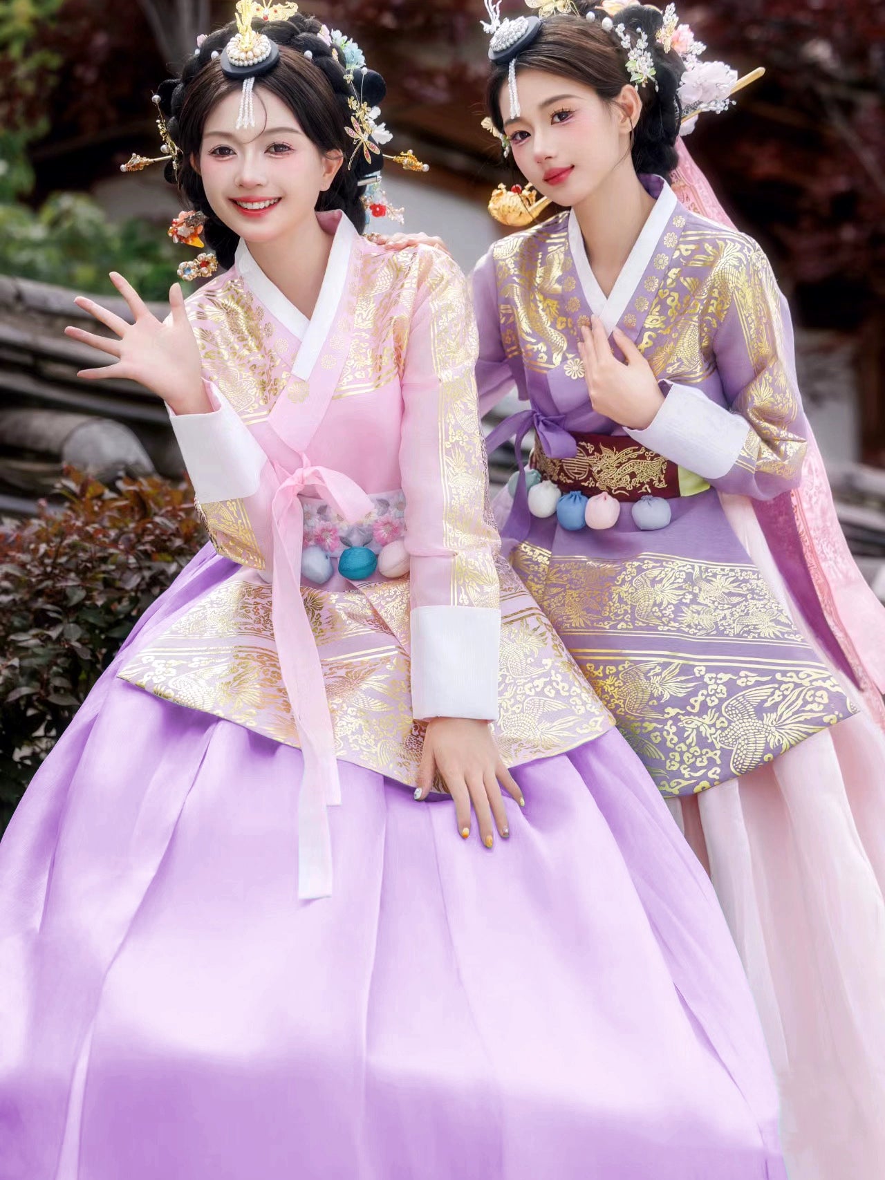 Elegant pink and purple Hanbok with intricate gold patterns, worn by two women.