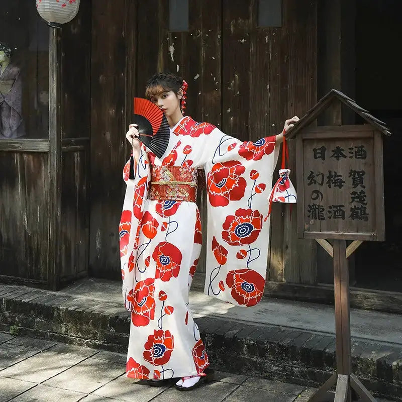 Full-length white and red Japanese kimono dress with artistic floral prints, styled with a matching obi belt and traditional accessories.