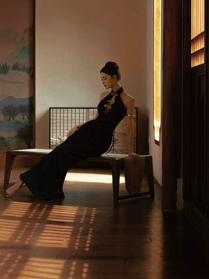 Retro black fishtail cheongsam dress styled in a serene setting, perfect for formal and elegant occasions.