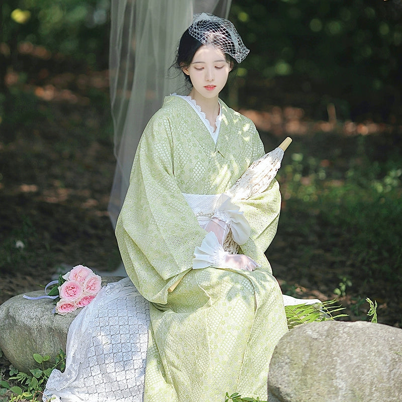 Vintage-inspired green kimono dress with intricate lace accents.