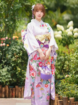 Elegant Japanese kimono dress with vibrant floral prints, big sleeves, and a matching handbag, perfect for formal occasions or celebrations.