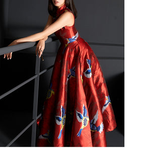 Close-up of red cheongsam dress highlighting bird and floral jacquard details.