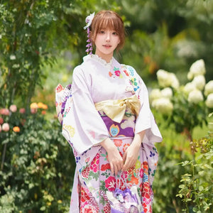 Close-up of a woman wearing a Japanese kimono with vibrant floral patterns and a decorative obi, perfect for cultural celebrations.