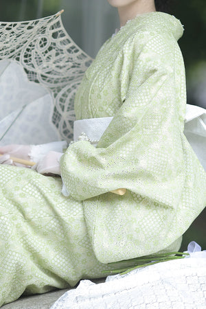 Side view of green kimono dress with intricate lace patterns.