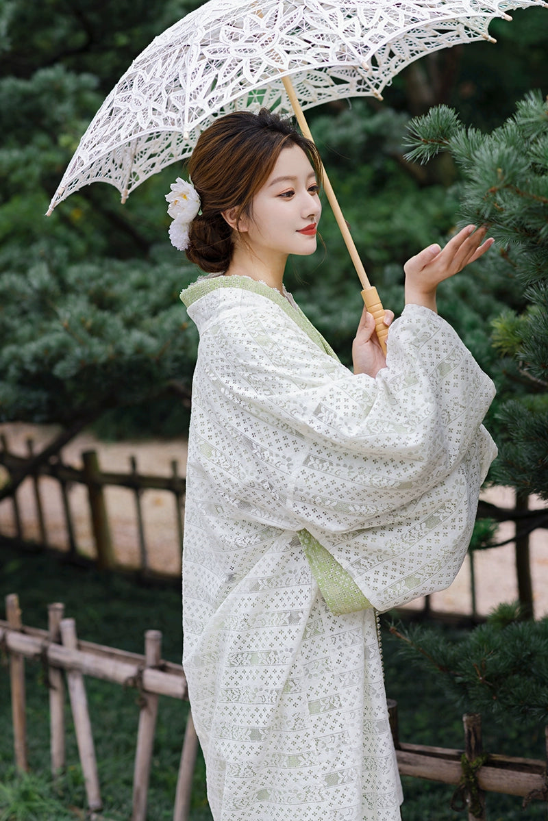 Elegant green kimono dress with lace parasol and floral hairpiece.