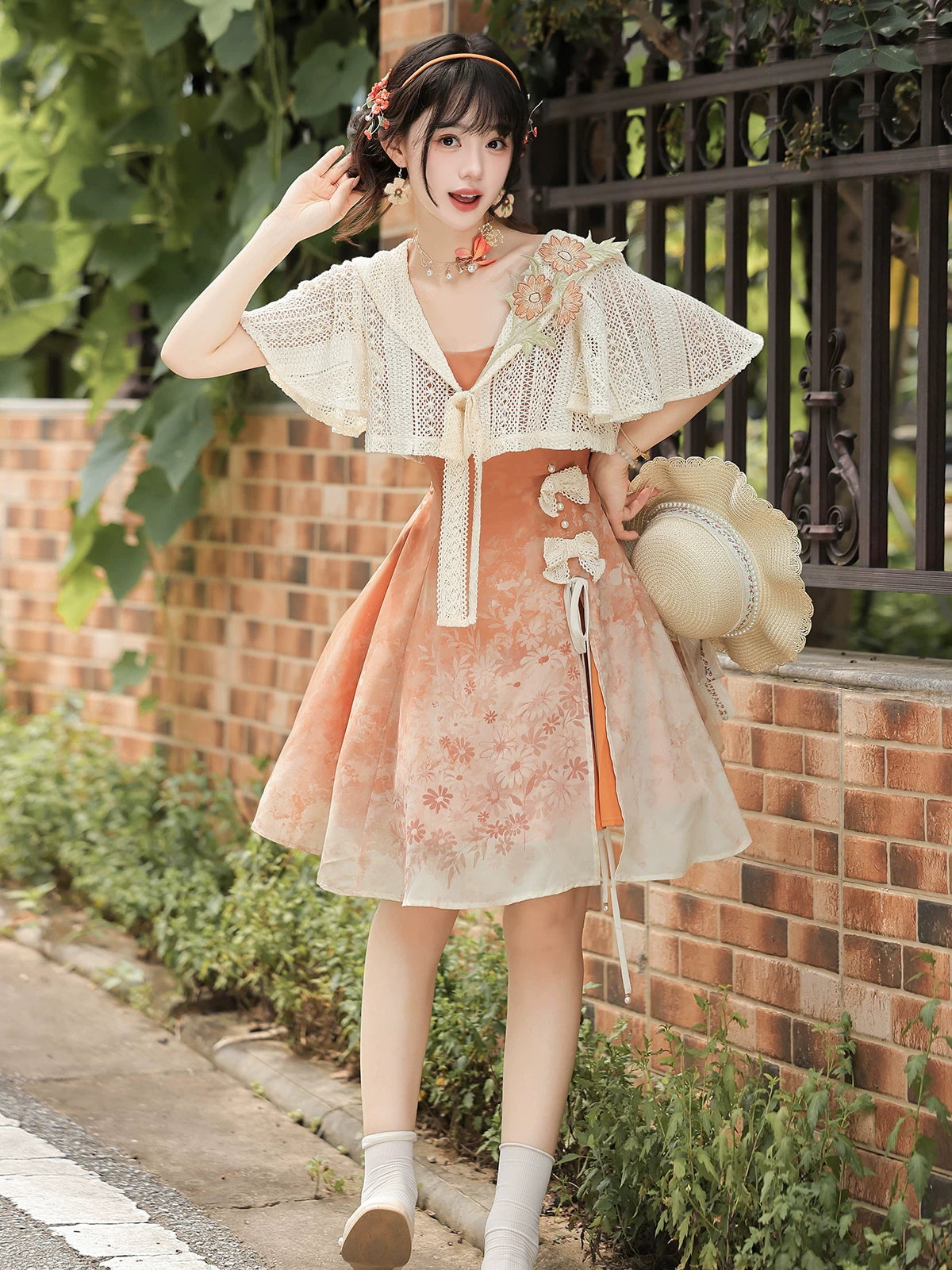 Peach floral dress and ivory lace capelet shown together outdoors